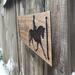 Custom horse competition stable sign with Dressage horse image, Dark Walnut wood stain, and font choice . Hung with a black suede cord